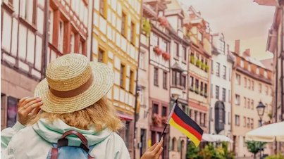 Reisende vor Fachwerkhäusern mit Deutschlandfahne