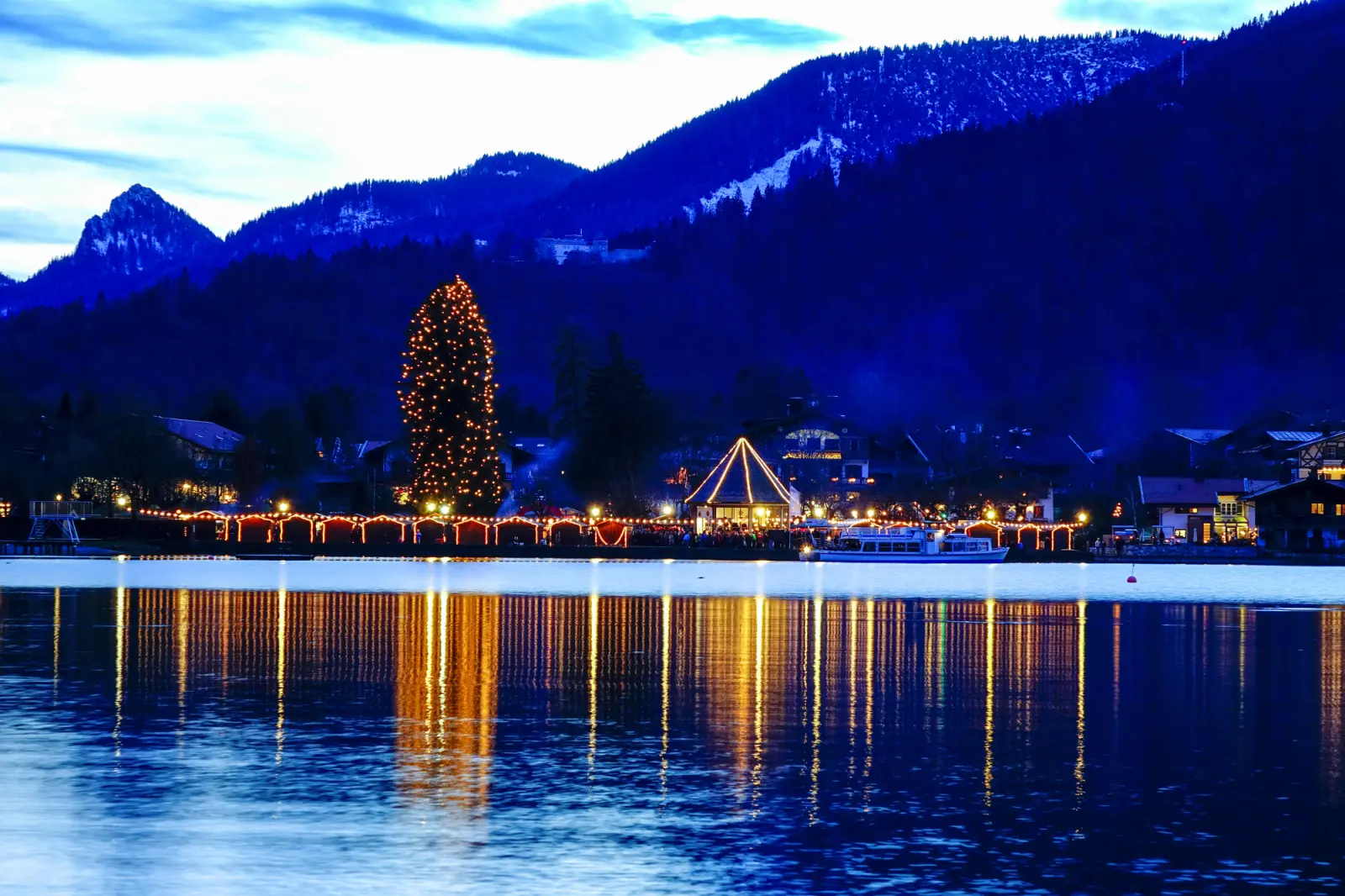 Bergsee und beleuchtete Weihnachtsdekoration bei Abenddämmerung in Rottach-Egern