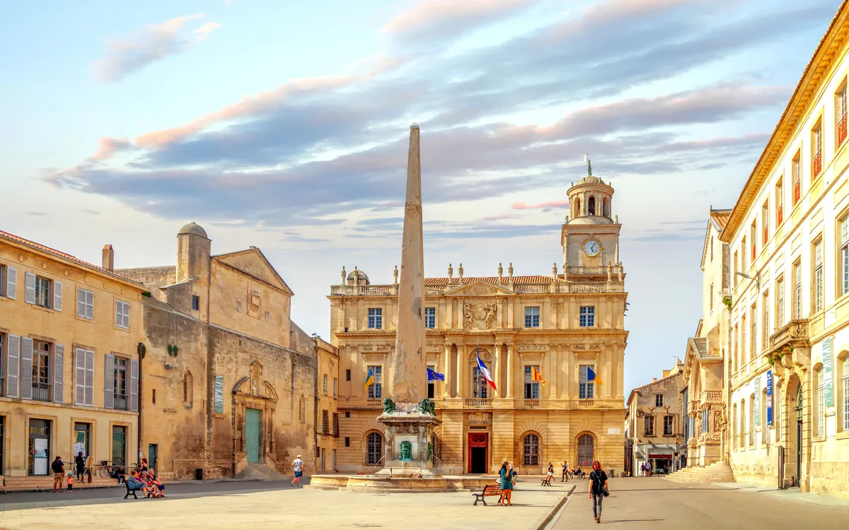 Historischer Platz mit Obelisk und alten Gebäuden bei Sonnenuntergang.