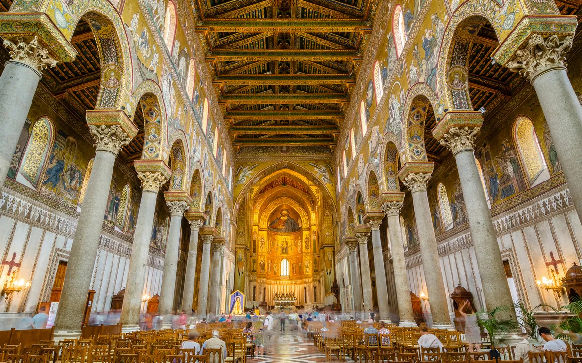 Prunkvolle Innenansicht einer prachtvoll verzierten Kathedrale mit Bögen und Mosaiken.