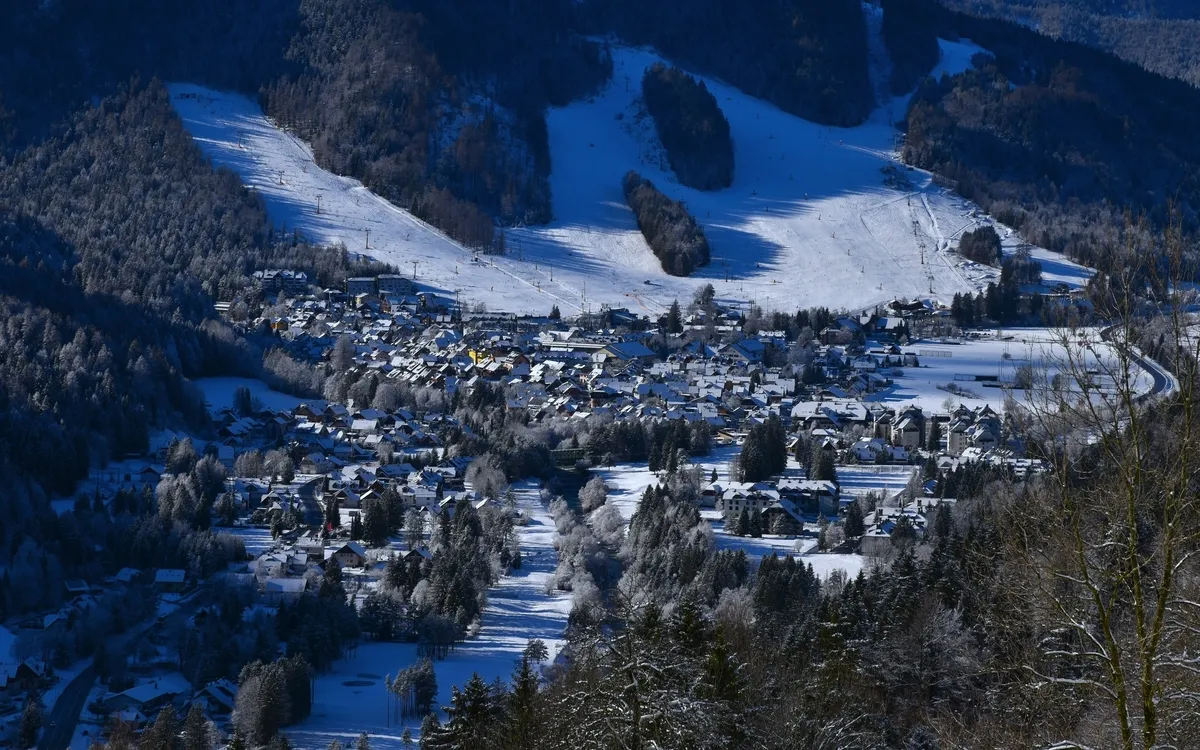 Schneebedeckte Berglandschaft mit einem Dorf.