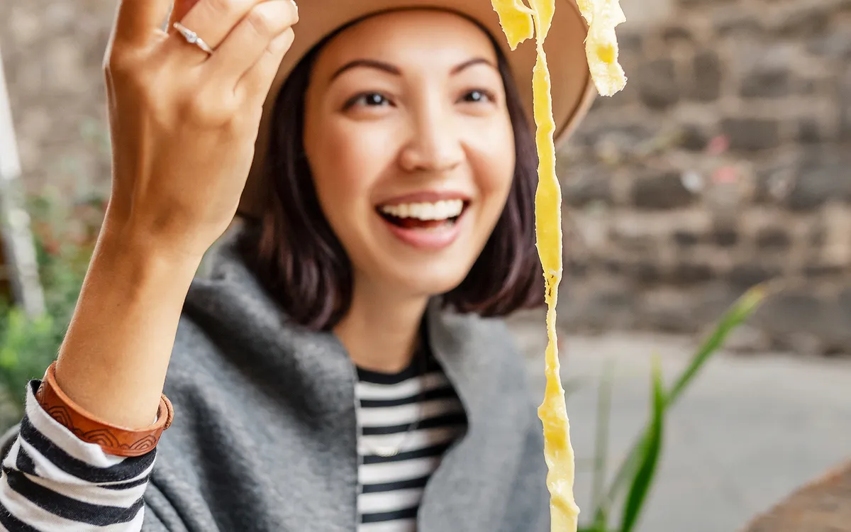 Frau genießt Pasta mit Trüffeln in einem italienischen Restaurant im Freien.