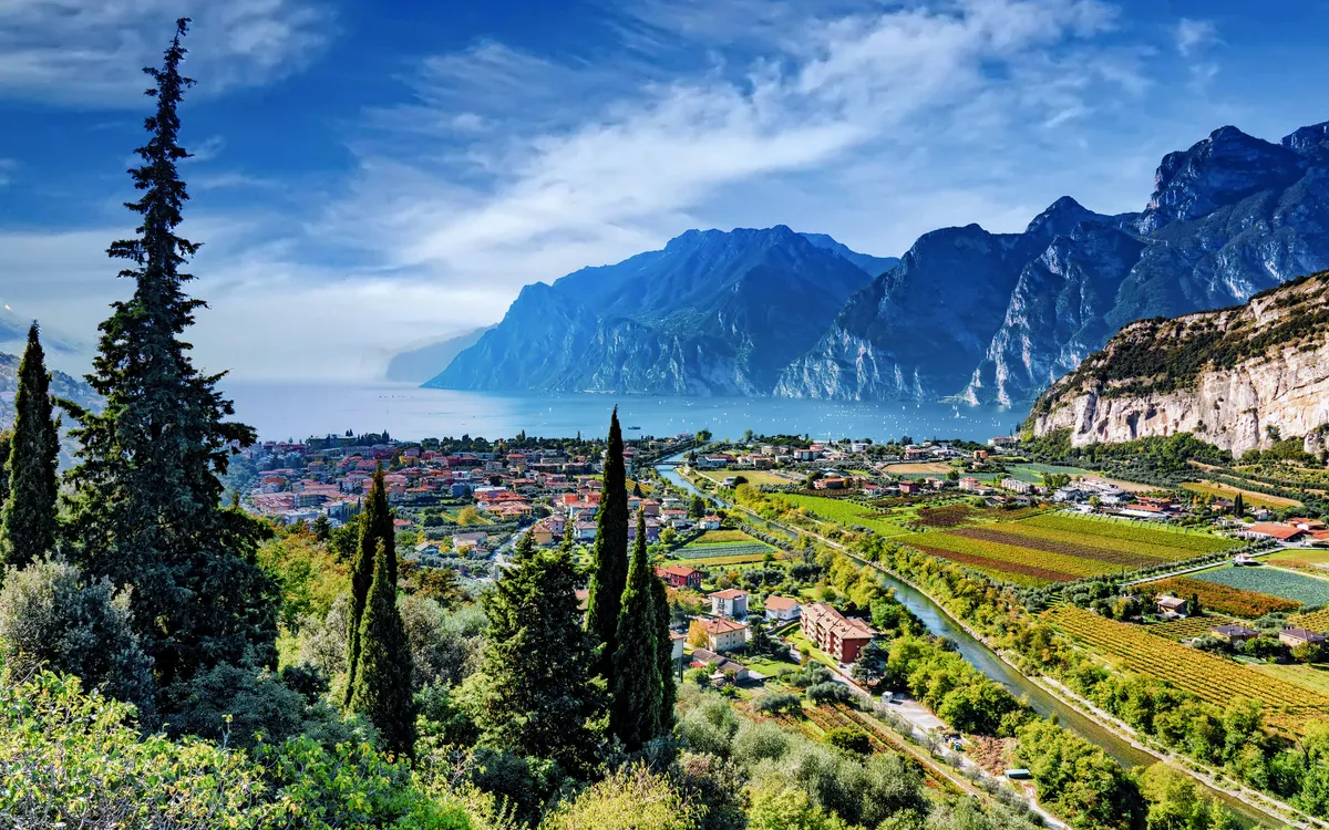 Aussicht auf den Gardasee mit den Orten Torbole, Arco und Riva del Garda umgeben von den Alpen.