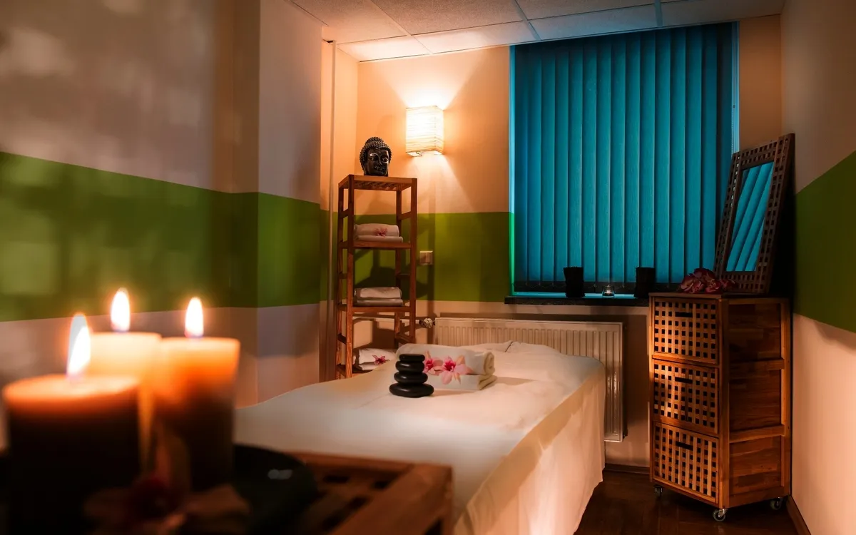 Entspannungsraum mit Massagebett, Kerzen und Regalen im AHORN Waldhotel Altenberg.