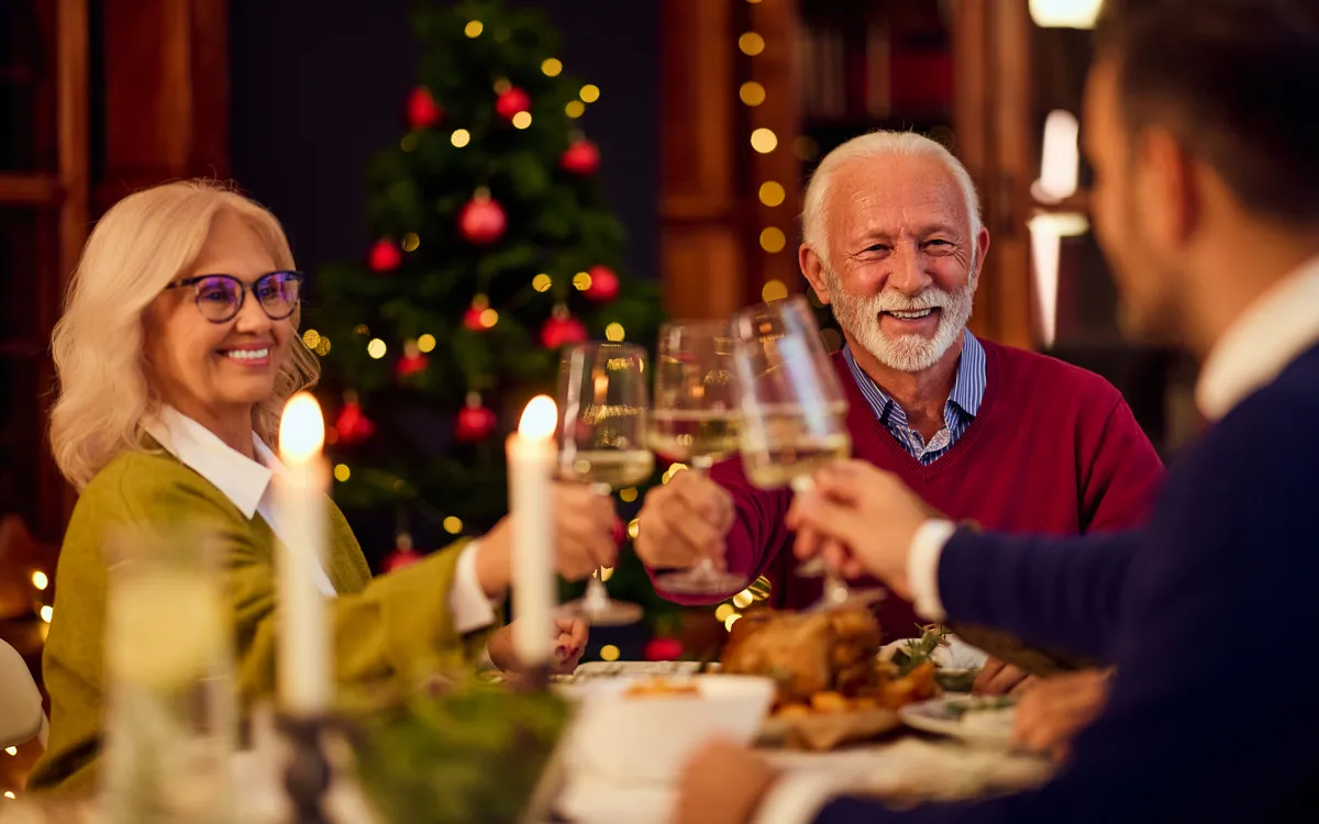 Ältere Erwachsene feiern und stoßen an einem festlichen Abendessen an.