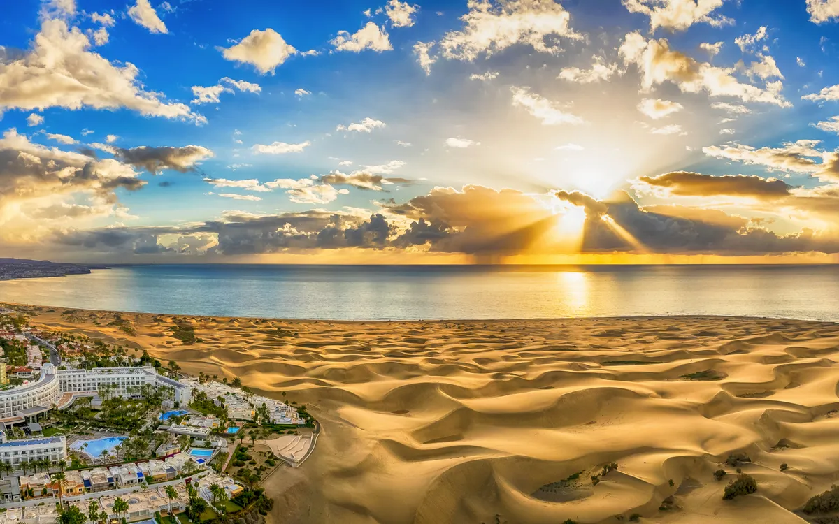 Panoramablick auf Dünenlandschaft mit Sonnenuntergang am Meer