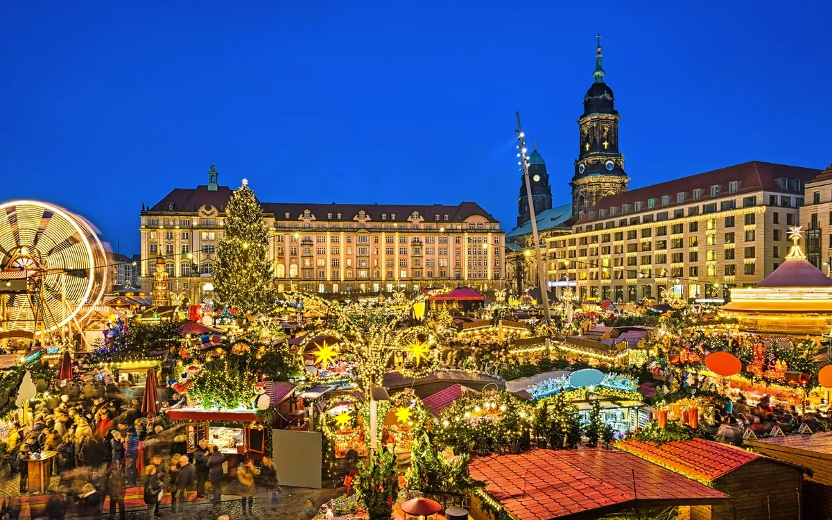Beliebter Weihnachtsmarkt in einer historischen europäischen Stadt bei Nacht.