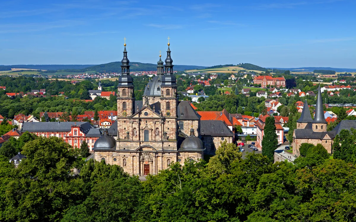 Barockkathedrale in Landschaft bei klarem Himmel und grüner Umgebung.