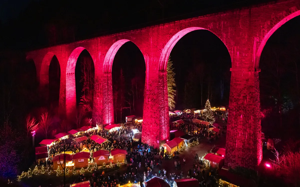 Viadukt bei Nacht mit Weihnachtsmarkt und stimmungsvoller Beleuchtung.