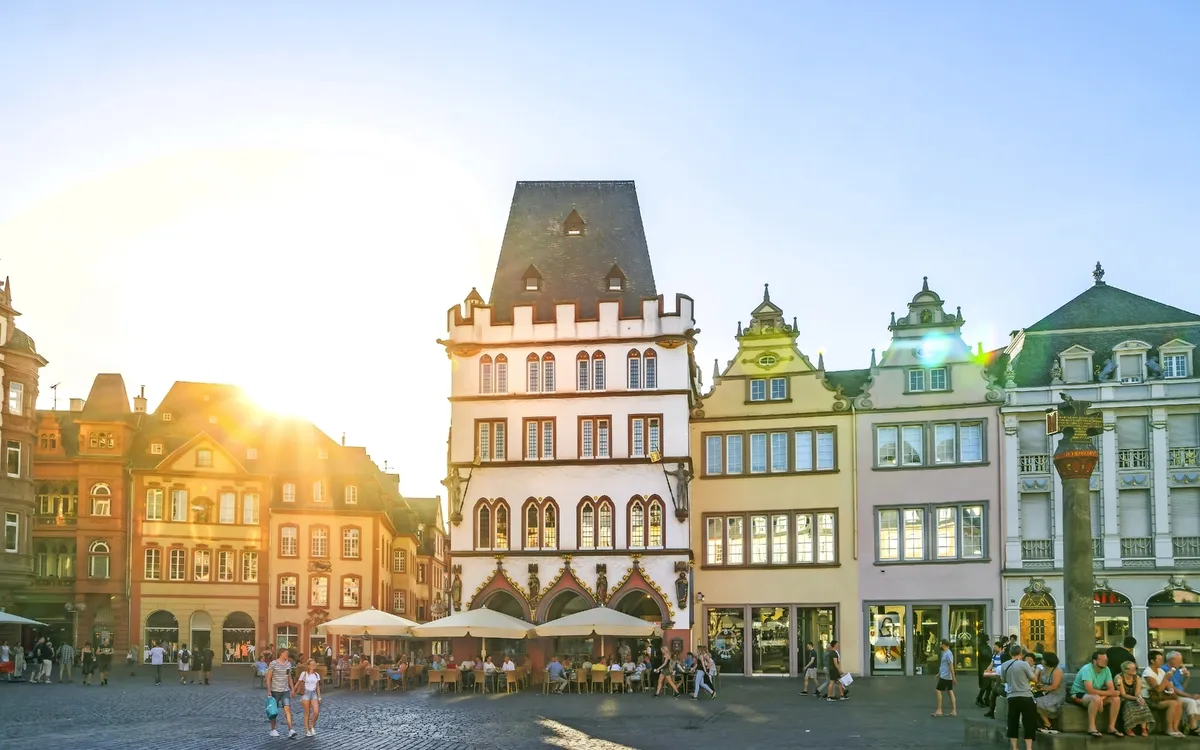 Historische Gebäude auf einem sonnigen Platz mit Menschen.