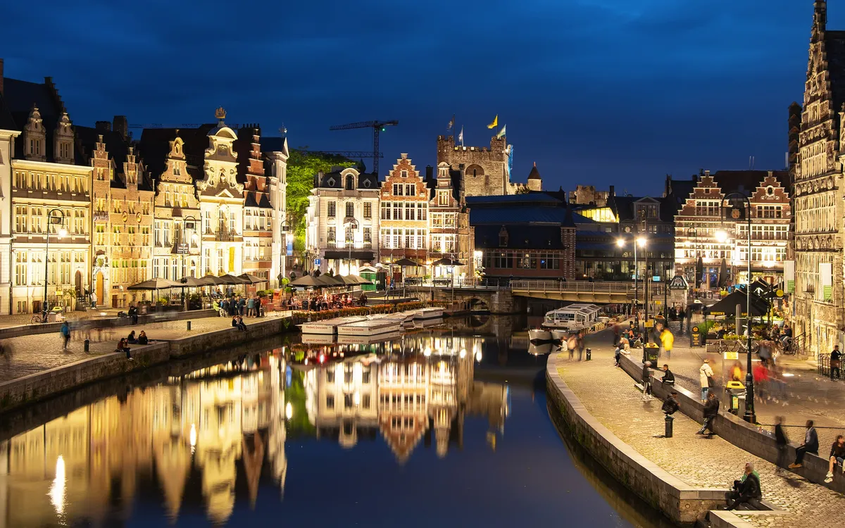 Panorama einer beleuchteten Architekturkulisse bei Nacht entlang eines Wasserkanals.